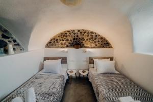 2 camas en una habitación pequeña con techo en Pueblo Viejo Suites en Kamari
