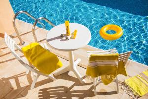 a table and chairs next to a swimming pool at AQI Skanes Resort in Monastir