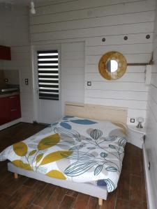 Mortagne-sur-SèvreにあるVilla Colonialeの白い壁のベッドルーム1室(ベッド1台付)