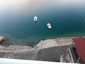 deux bateaux flottant dans l'eau à côté d'un bâtiment dans l'établissement Apartments Leža, à Neum