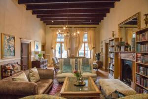 a living room filled with furniture and a chandelier at Pontac Manor Hotel & Restaurant in Paarl