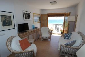 a living room with chairs and a television and a balcony at AR3B, Arsenal Barry, en primera línea in Villajoyosa