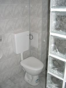 La salle de bains est pourvue de toilettes blanches et d'étagères. dans l'établissement Ulitsa Treti Mart North, à Primorsko
