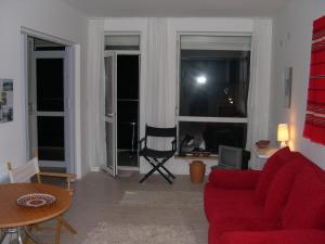 - un salon avec un canapé rouge et 2 fenêtres dans l'établissement Ulitsa Treti Mart North, à Primorsko