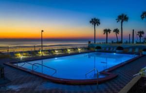 a large swimming pool with a beach view at Fountain Beach Resort - Daytona Beach in Daytona Beach
