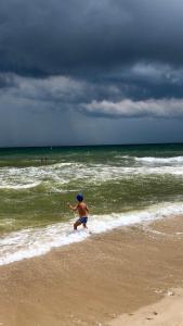 un hombre corriendo por la playa en el océano en Villa Bossa, en Zatoka