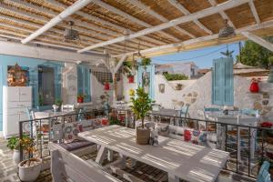 a patio with a table and chairs on a balcony at Sonio Beach - Que Bella Collection in Platanias