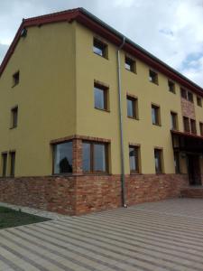 a large yellow building with a brick at Penzión Petrov grunt in Košúty