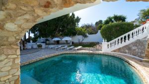 a swimming pool in a villa with a stone wall at Mijas Residence in Mijas