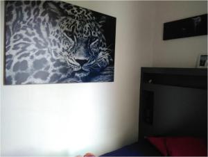 una foto de un leopardo colgando en una pared en Chez Caro en Epinois