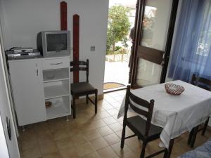 a room with a table and a tv and a table and chairs at Apartments Ruzica - 50 m from sea in Jezera