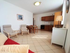Cà Bottrigo في باردولينو: مطبخ وغرفة معيشة مع طاولة وكراسي