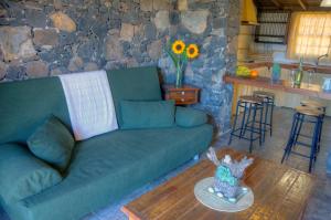 a living room with a green couch and a table at Jardin Las Hayas in Valle Gran Rey