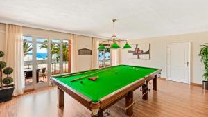 a pool table in a living room with a pool at Macdonald Leila Playa Resort in La Cala de Mijas