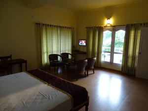 - une chambre avec un lit, une table et des chaises dans l'établissement Sealine Beach Resorts, à Cherai Beach