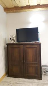 a flat screen tv on a wooden cabinet with speakers at Miodowy Kociołek in Mrągowo