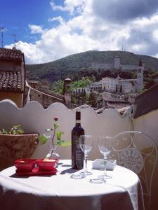 een fles wijn op een tafel met glazen bij Sotto i tetti del borgo in Spoleto