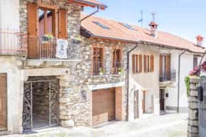 a stone house with a garage in a street at Guest House Casa del Folletto in Stresa