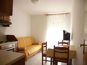 una cucina e un soggiorno con divano e tavolo di Apartments Srećko - close to center with terrace a Kukljica (Cuclizza)