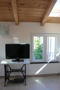 a tv on a table in a room with a window at Le Caravelle in Levanto