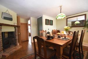 a dining room with a table and a fireplace at Little Turret in St. Leonards