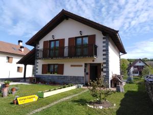 a white house with a balcony and a yard at Albergue Irugoienea in Espinal-Auzperri