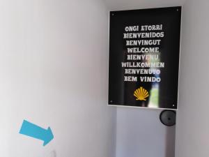 a black sign on a wall with words on it at Albergue Irugoienea in Espinal-Auzperri