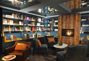 a library with couches chairs and bookshelves at Park South Hotel, part of JdV by Hyatt in New York