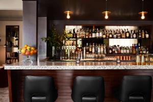 a bar with a counter with bottles of alcohol at The Laurel Inn, part of JdV by Hyatt in San Francisco