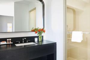 
a bathroom with a sink, mirror, and towel rack at Hotel Kabuki, part of JdV by Hyatt in San Francisco
