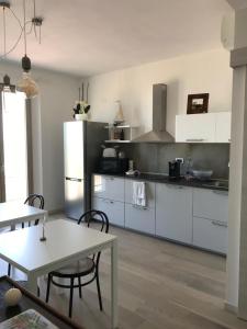 a kitchen with a table and a white refrigerator at B&b Salsedine in Civitanova Marche