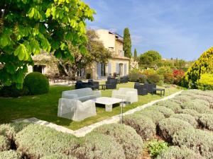 um jardim com sofás e uma mesa em frente a uma casa em Domaine de l'Enclos em Gordes