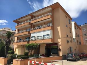 a building with cars parked in front of it at Piso céntrico 2 habitaciones cerca del mar in Hospitalet de l'Infant