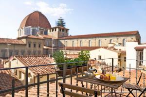 una mesa con un plato de comida en el balcón en One of a kind Near The Duomo w/Balcony Palace Apt, en Florencia