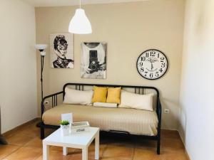 コラレホにあるApartamento Céntrico Playa Corralejo 2のベッド1台、時計、テーブルが備わる客室です。
