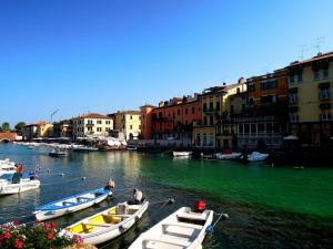 dwie łodzie zacumowane w rzece z zieloną wodą w obiekcie Appartamento La Regina Del Garda w mieście Peschiera del Garda