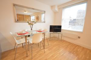 a dining room with a table and chairs and a television at 4B Soho Studios 4th floor by Indigo Flats in London