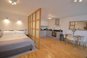 a bedroom with a bed and a table and a kitchen at 4B Soho Studios 4th floor by Indigo Flats in London