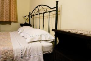 1 dormitorio con 1 cama con almohadas blancas en La Fattoria en Cusano Mutri