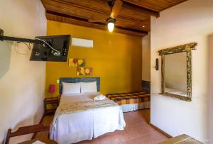 1 dormitorio con cama y espejo en Pousada Pepalantus, en Serra do Cipo