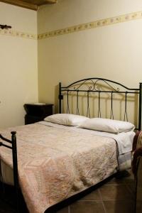 1 dormitorio con cama negra y almohadas blancas en La Fattoria en Cusano Mutri