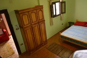 a bedroom with a bed and a wooden cabinet at Thomas' in Cairo