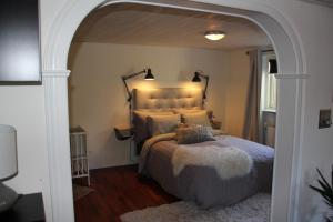 Villa Toften في سكاندربورغ: غرفة نوم مع سرير كبير مع ممر