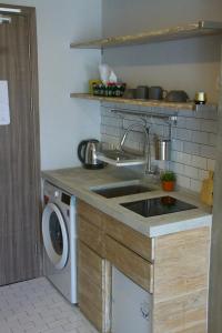 a kitchen with a sink and a washing machine at DreamWood @ Galeri Ciumbuleuit in Bandung