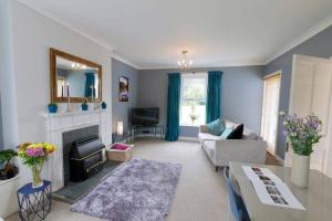 a living room with a couch and a fireplace at Treetops in Gatehouse of Fleet