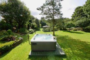 a hot tub sitting on a deck in a yard at Treetops in Gatehouse of Fleet