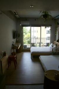 a room with two beds and a balcony at DreamWood @ Galeri Ciumbuleuit in Bandung