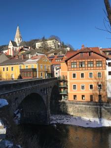 a bridge over a river in a city with buildings at Apartment zur Brücke in Murau