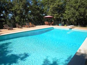 uma grande piscina azul com cadeiras e um guarda-sol em Residence Gello em Arezzo
