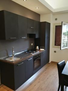 a kitchen with black cabinets and a sink at Il Giardino Dei Limoni in Aci Castello